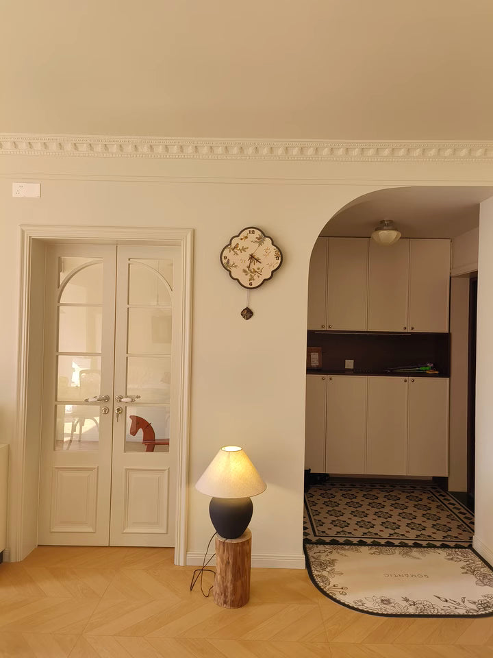 birds and leaf black and white clock placed beside door