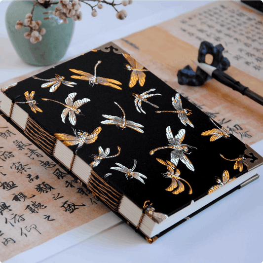 dragon fly notebook different size on table