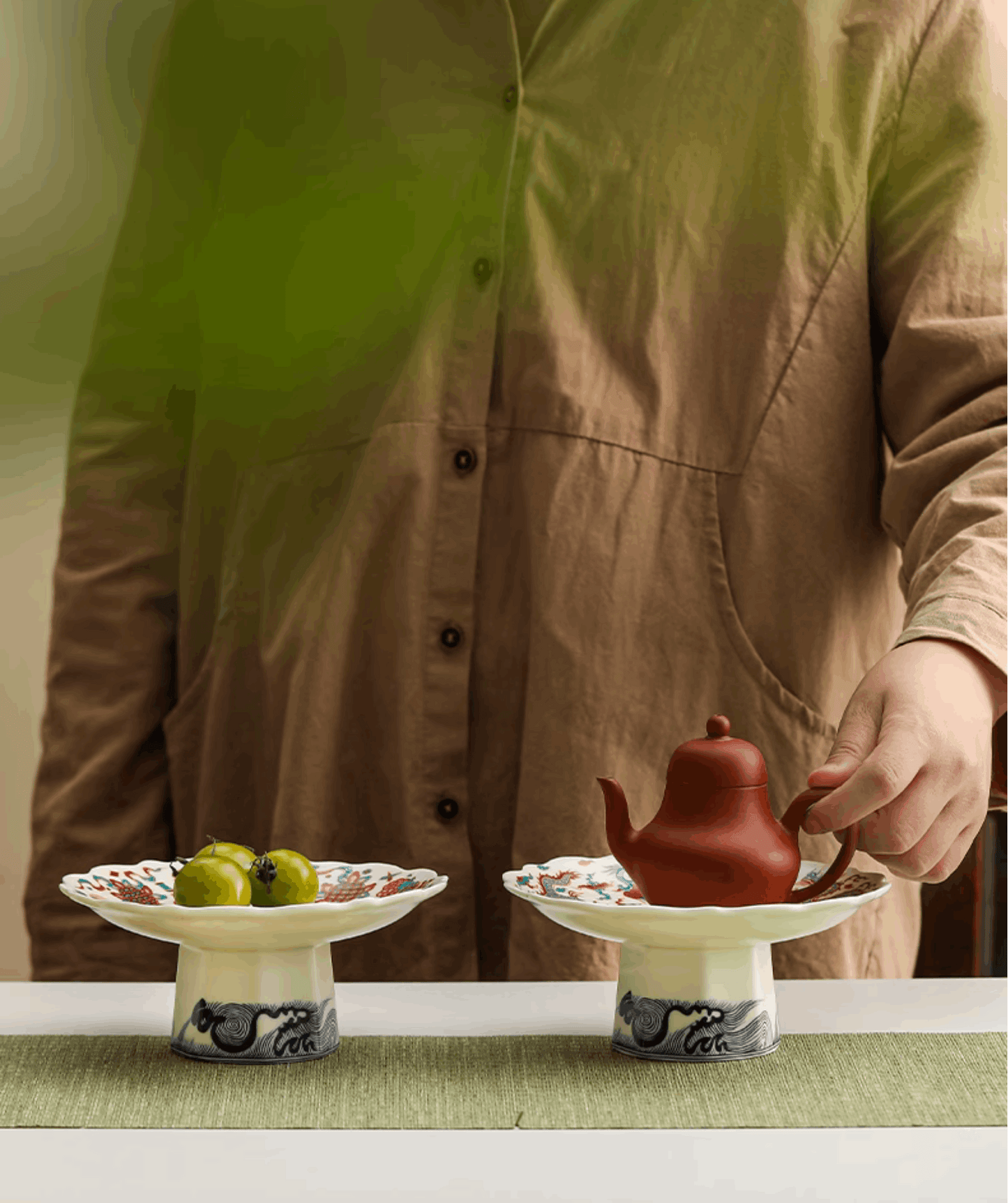 serving platter side by side one with fruits on one with teapot on