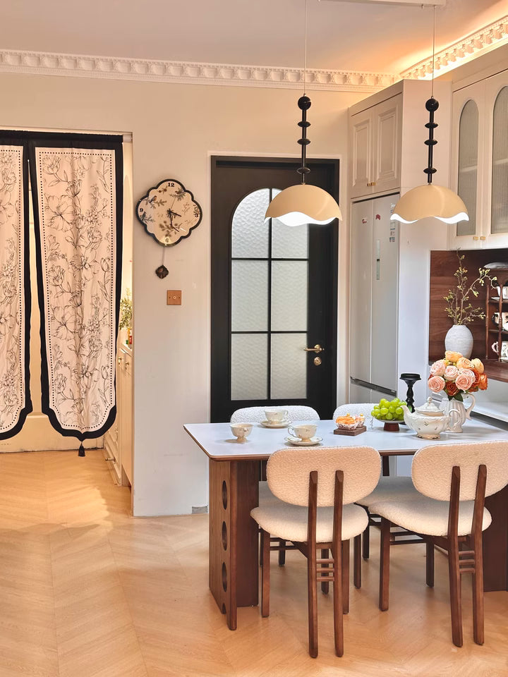 birds leaf black and white clock placed at dining area with orange light