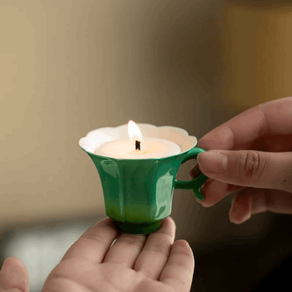 green candle lit up on hand with curly corner