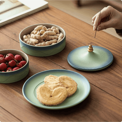green serving platter on wooden table with fruits and peanut