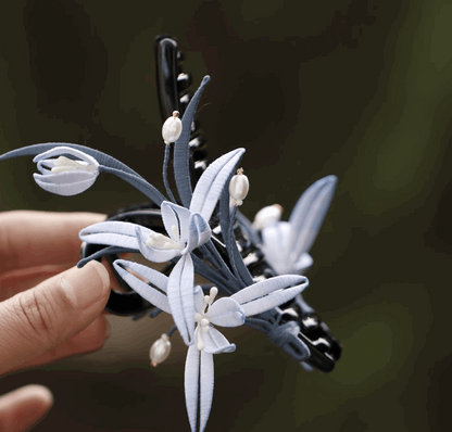 pearl with light blue flower claw clip on hair side view on hand