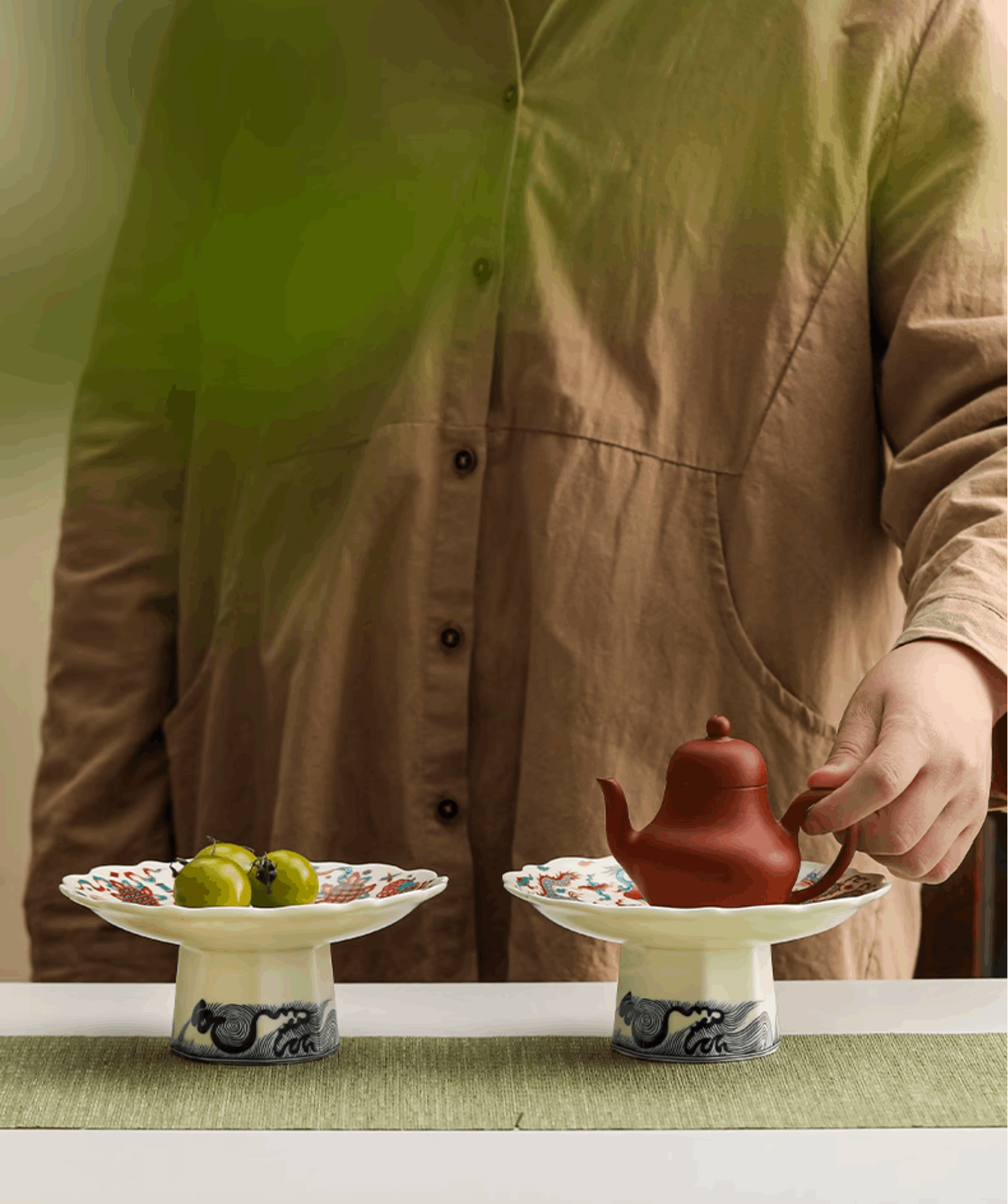 serving platter side by side one with fruits on one with teapot on
